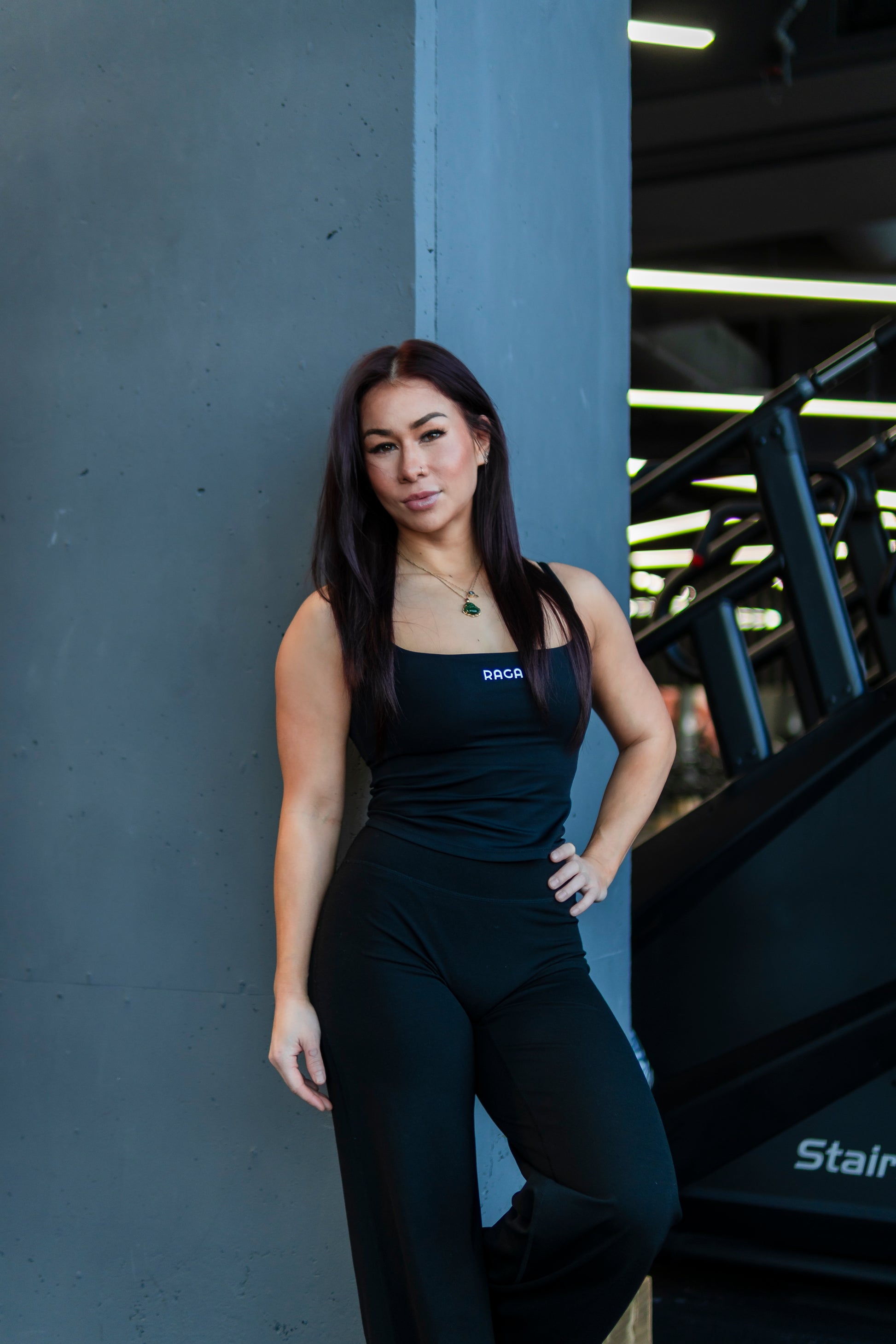 Women's black flare gym pants with a body-hugging fit through the hips and thighs, finished with an elegant flared leg.